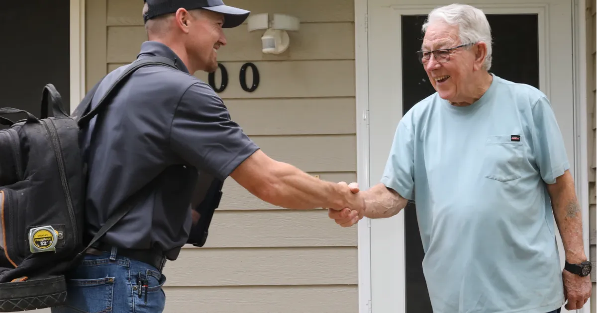 Image of a Hooley Heating & Air technician shaking hands with a Fort Collins customer for thermostat services